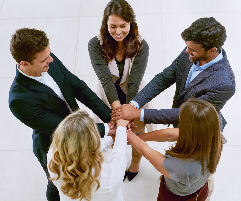 Equipo uniendo las manos al centro